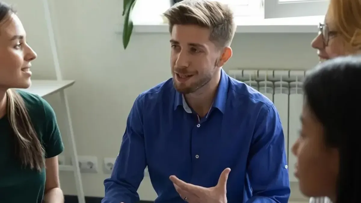 A man talking and gesturing during a group conversation