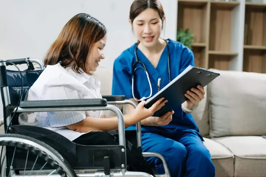 A nurse assisting an NDIS participant who uses a wheelchair