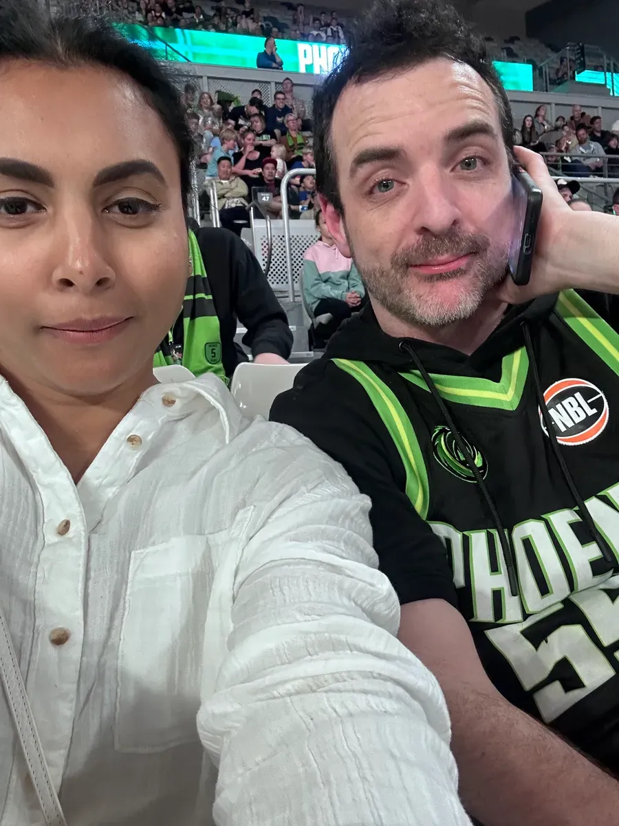 Two people smiling together at a community sports event