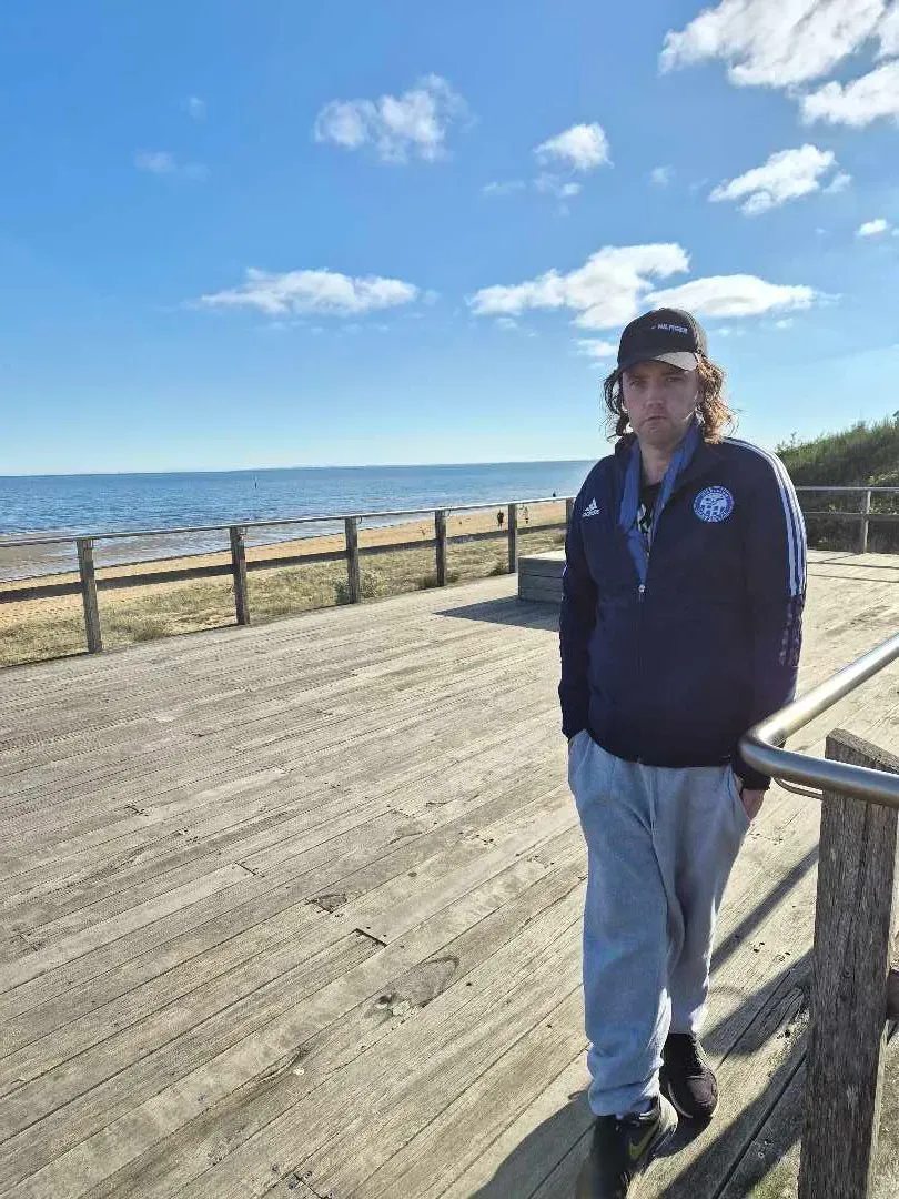 A young person out on a seaside boardwalk on a sunny day